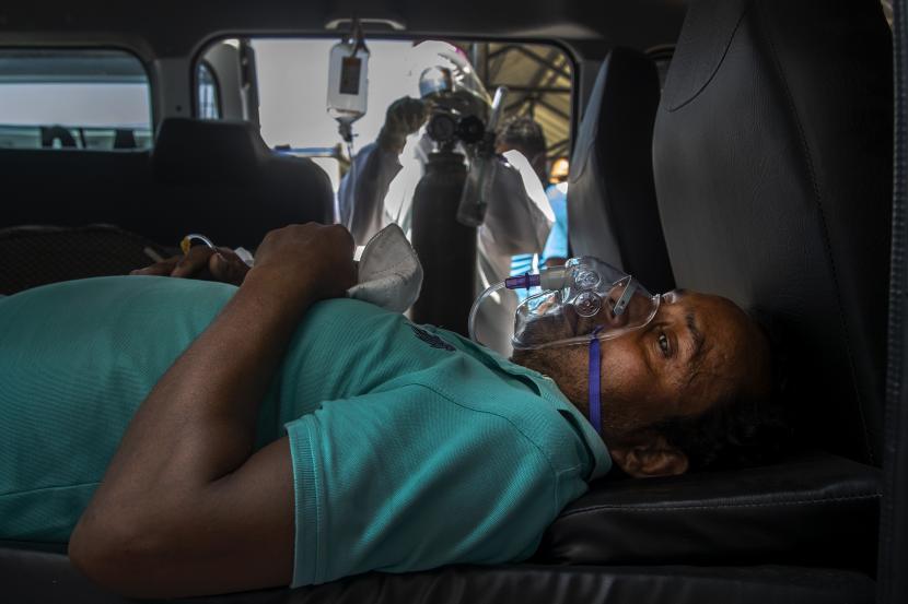 Seorang pasien Covid-19 mengambil oksigen di dalam kendaraan di luar rumah sakit pemerintah di Gauhati, India, Senin, 24 Mei 2021.