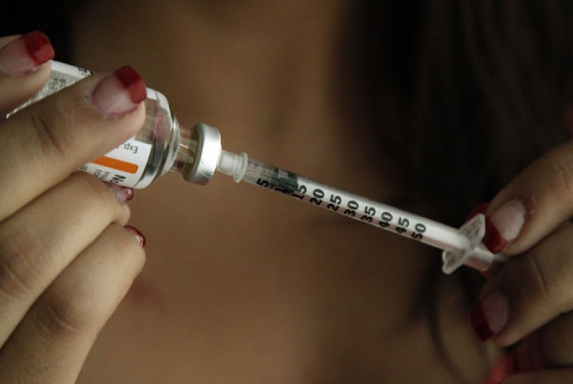 Seorang pasien penderita diabetes tengah menyuntikkan obat insulin. 