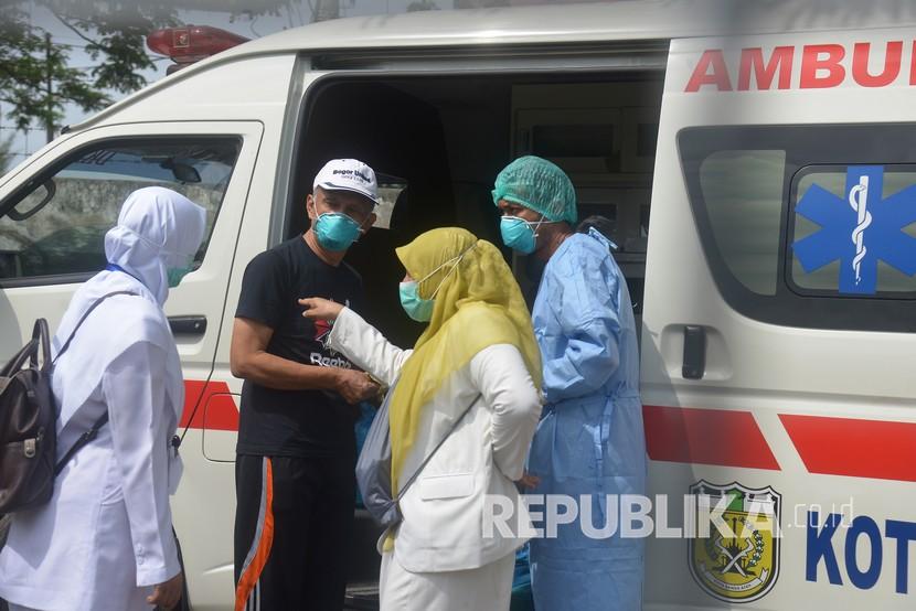 Seorang pasien positif Covid-19 (kedua kiri) yang dinyatakan sembuh bersiap menaiki mobil ambulan saat pemulangan di Rumah Sakit Zainal Abidin, Banda Aceh, Senin lalu.