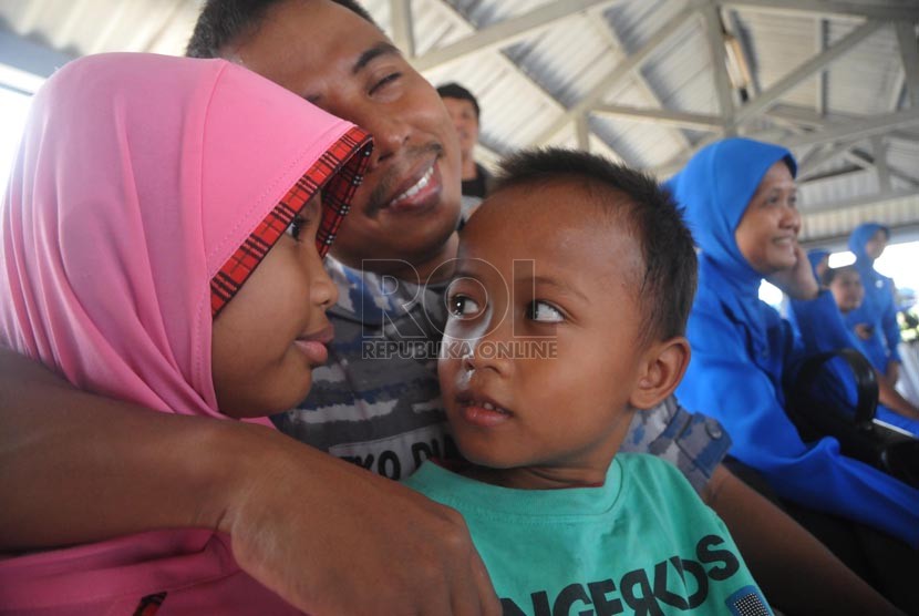 Seorang pasukan dari Satgas Rim of The Pacific (Rimpac) 2014 memeluk anaknya saat tiba di Dermaga Kolinlamil, Tanjung Priok, Jakarta Utara, Selasa (2/9).( Republika/Rakhmawaty La'lang)