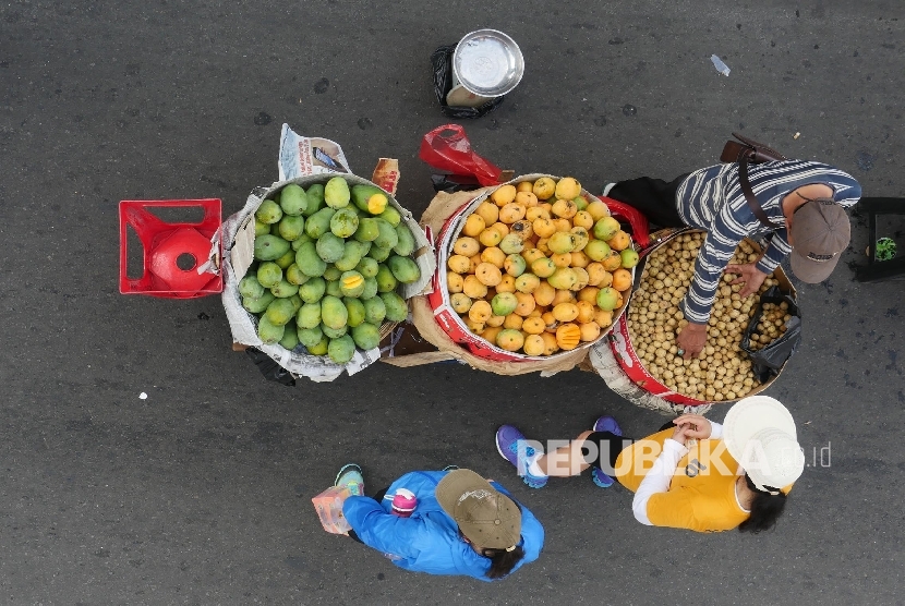 Seorang pedagang buah melayani konsumennya saat akan membeli dagangannya di Jl Thamrin Jakarta, Ahad (9/7), saat diberlakukannya waktu Car Free Day (CFD).