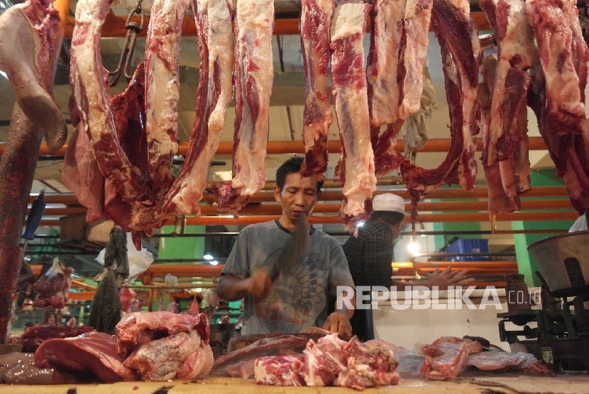  Seorang pedagang daging sedang memotong rusuk-rusuk sapi di Pasar Jatinegara, Jakarta.