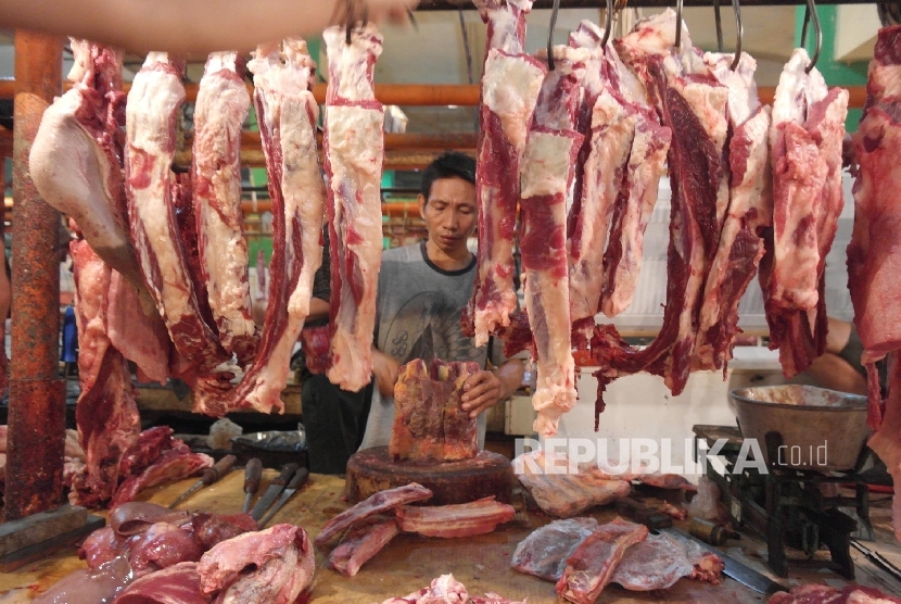 Seorang pedagang daging sedang memotong rusuk sapi (Ilustrasi)