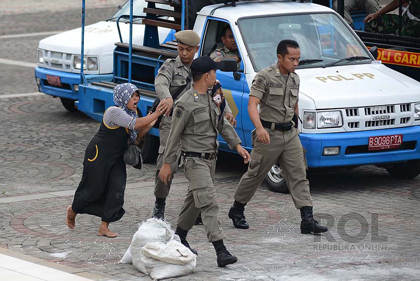  Petugas Satpol PP DKI merazia pedagang kaki lima (PKL) saat razia di kawasan Monumen Nasional (Monas), Jakarta Pusat, Selasa (23/12).