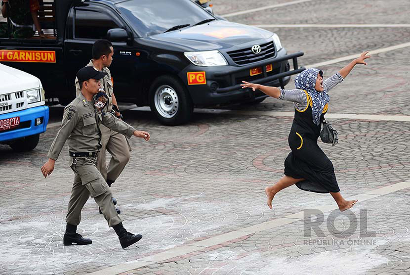 Seorang Pedagang Kaki Lima (PKL) melarikan diri dari kejaran petugas saat Satpol PP melakukan razia di kawasan Monumen Nasional (Monas), Jakarta Pusat, Selasa (23/12).(Republika/Raisan Al Farisi)