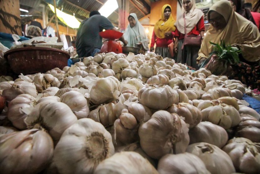 Seorang pedagang melayani pembeli bawang putih di pasar tradisional Inpres Lhokseumawe, Aceh. Senin (3/5/2019).