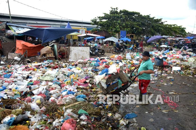 Seorang pedagang membuang sampah di depan Pasar Pagi Arengka di Kota Pekanbaru, Riau, Rabu (6/1/2021). Buang Sampah Sembarangan di Pekanbaru, Awas Denda Rp 5 Juta
