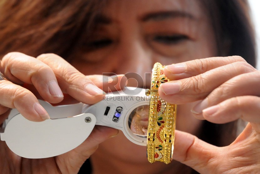 Seorang pedagang memeriksa kadar emas sebuah perhiasan di sentra perhiasan Cikini, Jakarta, Selasa (12/2). (Republika/Aditya Pradana Putra)
