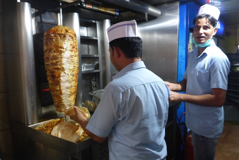 Antropologi Makan Orang Arab . Seorang pedagang menyiapkan jajanan shawarma di tokonya sekitar Masjid Nabawi, Madinah, Arab Saudi.