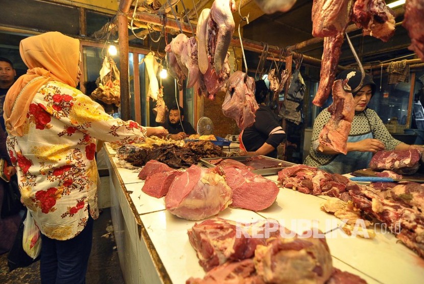 Seorang pedang daging sapi melayani pembeli, di Pasar Kosambi, Kota Bandung, Senin (4/7). Pasca Lebaran harga daging sapi masih stabil Rp 130.000 ribu per kilogram. (Mahmud Muhyidin) 