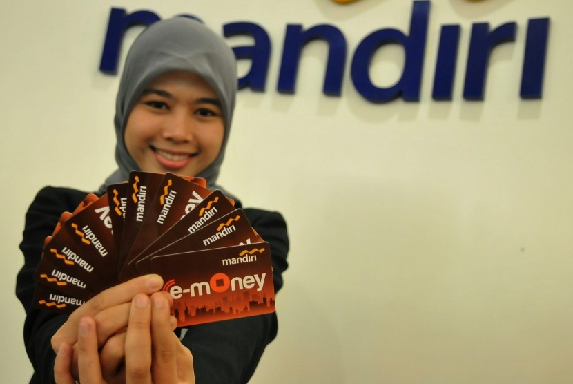 Seorang pegawai menunjukkan model layanan uang elektronik (E-Money) berbentuk kartu dari Bank Mandiri, di Jakarta, Selasa (51/7).  (Republika/Prayogi).