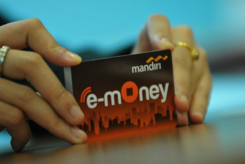 Seorang pegawai menunjukkan model layanan uang elektronik (E-Money).