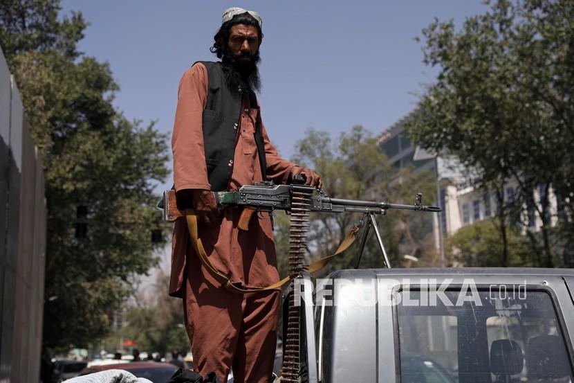  Seorang milisiTaliban duduk di belakang kendaraan dengan senapan mesin di depan gerbang utama menuju istana kepresidenan Afghanistan, di Kabul, Afghanistan, Senin, 16 Agustus 2021. 