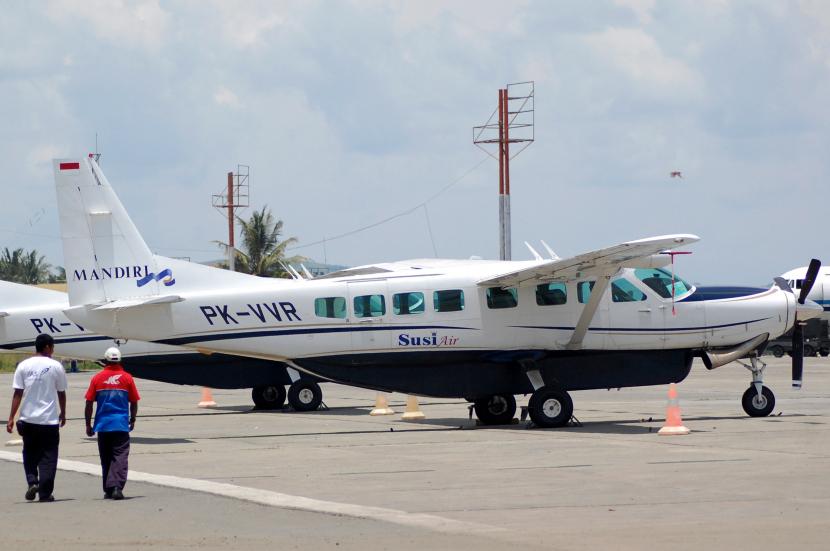 Seorang pekerja bandara melintas di samping Pesawat SUSI Air jenis Caravan C.208 B PK-VVR di Hangar Bandara Udara Sentani, Kab.Jayapura, Papua.
