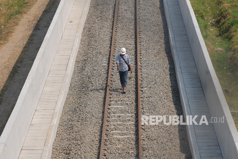 Seorang pekerja berjalan ditengah jalur rel kereta api Bandara Adi Soemarmo di Ngemplak, Boyolali, Jawa Tengah, Rabu (14/8/2019).