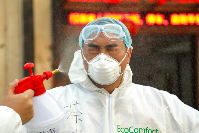Seorang pekerja dengan pakaian pelindung disemprot cairan desinfektan, ilustrasi