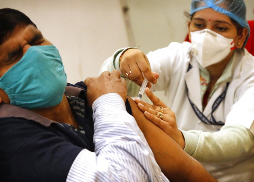 Petugas Kebersihan Terima Vaksin Covid-19 Pertama di India. Seorang pekerja kesehatan memberikan vaksin Covid-19 di sebuah Rumah Sakit di New Delhi, India, Sabtu, 16 Januari 2021. India mulai menyuntik petugas kesehatan pada Sabtu dalam kampanye vaksinasi Covid-19 terbesar di dunia.