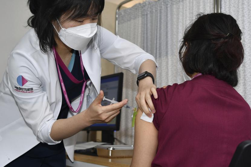  Seorang pekerja medis menerima dosis vaksin Pfizer BioNTech COVID-19 di pusat vaksinasi National Medical Center di Seoul Sabtu, 27 Februari 2021. Korea Selatan mulai memvaksinasi puluhan ribu pekerja di rumah sakit garis depan pada hari kedua program imunisasi masalnya.