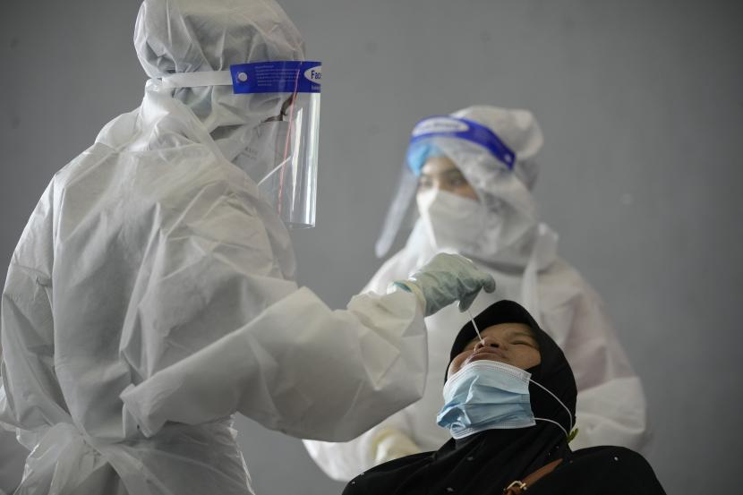  Seorang pekerja medis mengumpulkan sampel usap dari seorang wanita selama pengujian virus corona di pusat pengujian COVID-19 di Shah Alam, pinggiran Kuala Lumpur, Malaysia, Kamis, 27 Mei 2021. 