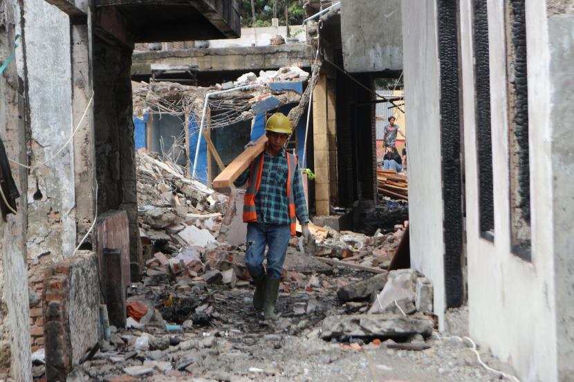 Seorang pekerja membawa kayu bahan bangunan di lokasi bekas kebakaran Pasar Gembrong, Cipinang Besar Utara, Jakarta Timur (ilustrasi)