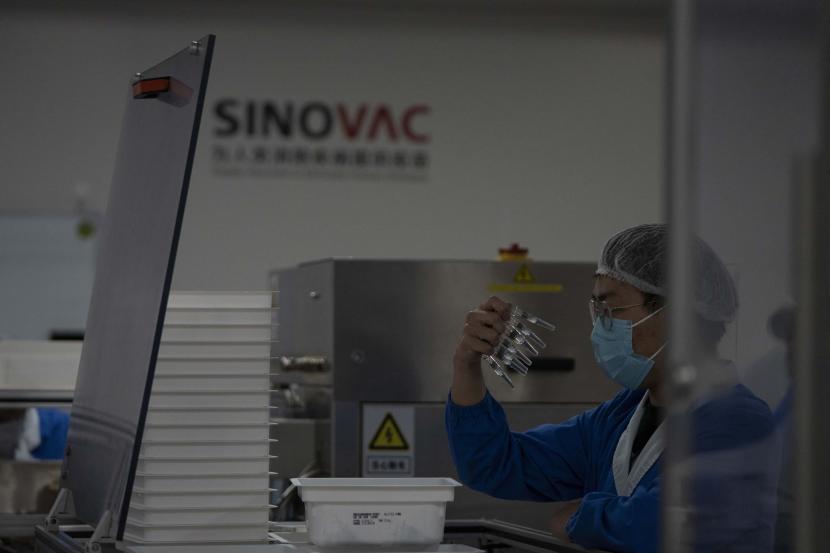 Seorang pekerja memeriksa jarum suntik Vaksin untuk COVID-19 yang diproduksi di pabrik vaksin SinoVac di Beijing.