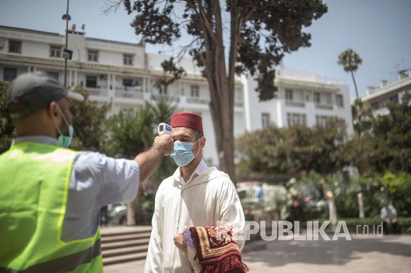 Seorang pekerja memeriksa suhu orang yang akan shalat di sebuah masjid di Rabat, Maroko (ilustrasi). Maroko meneken kontrak pembelian vaksin Covid-19 dengan perusahaan farmasi asal Rusia R-Pharm.