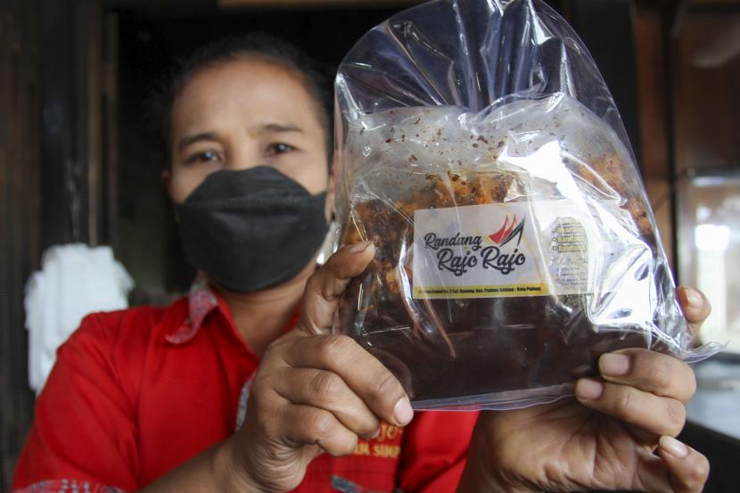 Seorang pekerja memperlihatkan rendang dalam kemasan di Padang, Sumatera Barat, Rabu (8/9/2021). Pemerintah Provinsi Sumatra Barat akan menambah anggaran untuk bantuan sertifikasi halal bagi UMK.
