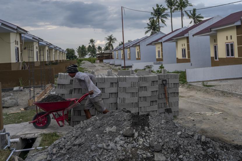 Seorang pekerja mengangkut material bangunan di proyek pembangunan perumahan Kredit Pemilikan Rumah (KPR) di Sigi, Sulawesi Tengah, Sabtu (31/7). PT Bank Tabungan Negara (Persero) Tbk menargetkan pembiayaan perumahan sebanyak 1,2 juta dalam lima tahun periode 2021 sampai 2025. 