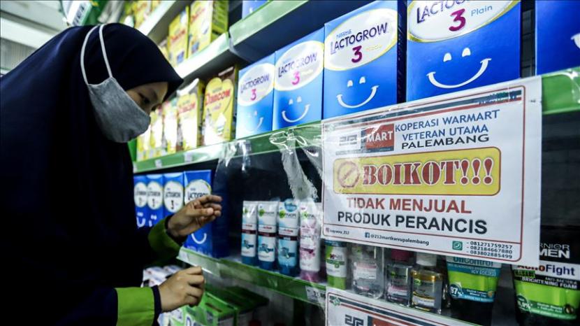 Seorang pekerja menurunkan produk Prancis yang dipajang di Supermarket di Palembang, Indonesia pada 9 November 2020. Tindakan ini sebagai tanggapan atas pernyataan kontroversial terkait umat Islam baru-baru ini yang dibuat oleh Presiden Prancis Emmanuel Macron. 