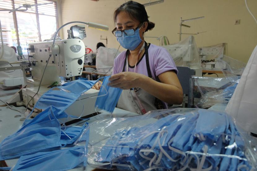 Seorang pekerja menyelesaikan pesanan masker berbahan kain spunbond di UPT Lembaga Latihan Kerja (LLK) Kabupaten Tabanan, Bali, Jumat (3/4/2020). Pembuatan ribuan masker dan telah disterilkan tersebut merupakan pesanan dari instansi pemerintah akibat minimnya alat pelindung diri (APD) di Bali untuk mencegah penyebaran COVID-19.
