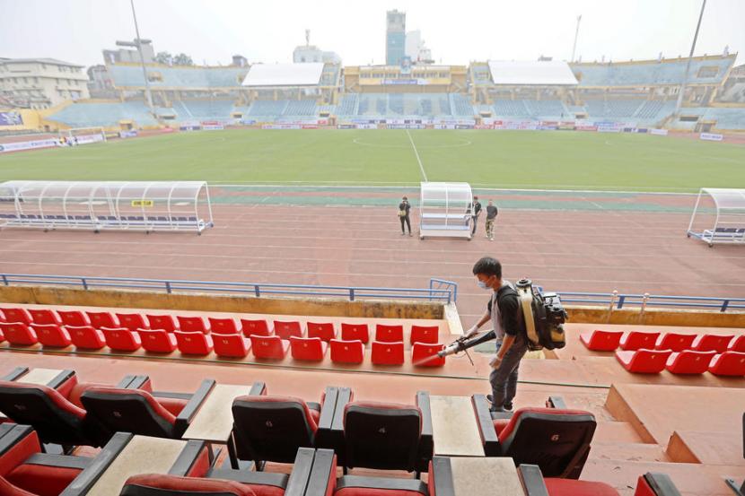 Seorang pekerja menyemprotkan desinfektan sebagai tindakan pencegahan terhadap coronavirus di Stadion Hang Day, menjelang pertandingan pembukaan musim V-League 2020 di Hanoi, Vietnam, 6 Maret lalu. Vietnam akan memulai kembali V-League pada 24 Mei. 