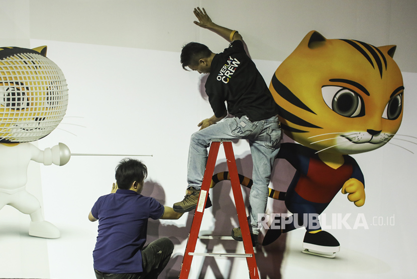 Seorang pekerja menyiapkan papan reklame SEA Games 2017 di media center di Kuala Lumpur, Malaysia, Jumat (11/8). 