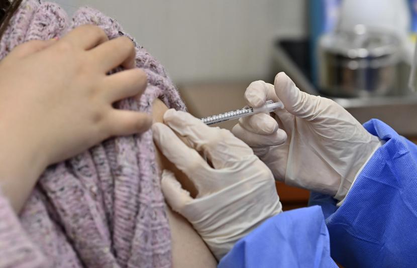  Seorang pekerja panti jompo, kiri, menerima dosis pertama vaksin AstraZeneca COVID-19 di pusat perawatan kesehatan di Seoul pada hari Jumat, 26 Februari 2021.