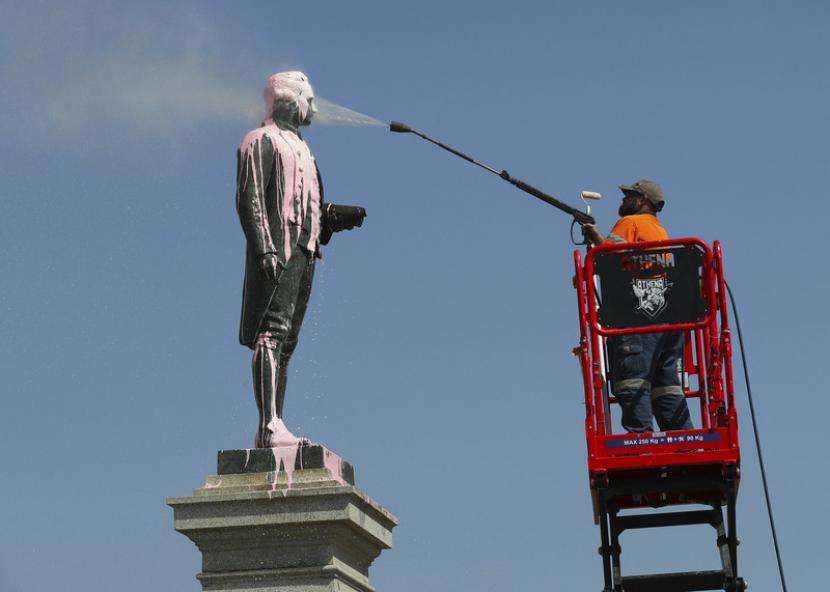 Seorang pekerja sedang membersihkan patung James Cook di Australia. Ilustrasi.