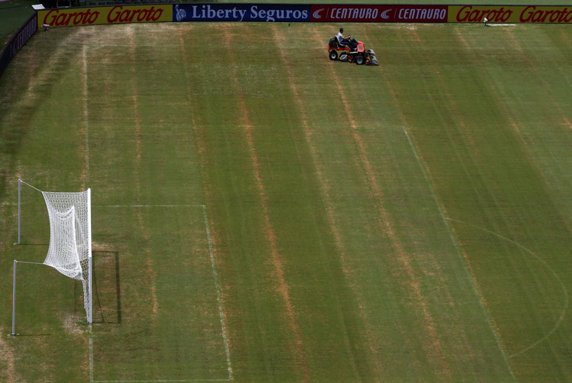 Seorang pekerja sedang mengendarai mesin pemotong rumpu di Stadion Arena Amazonia, Manaus, Rabu (11/6). 