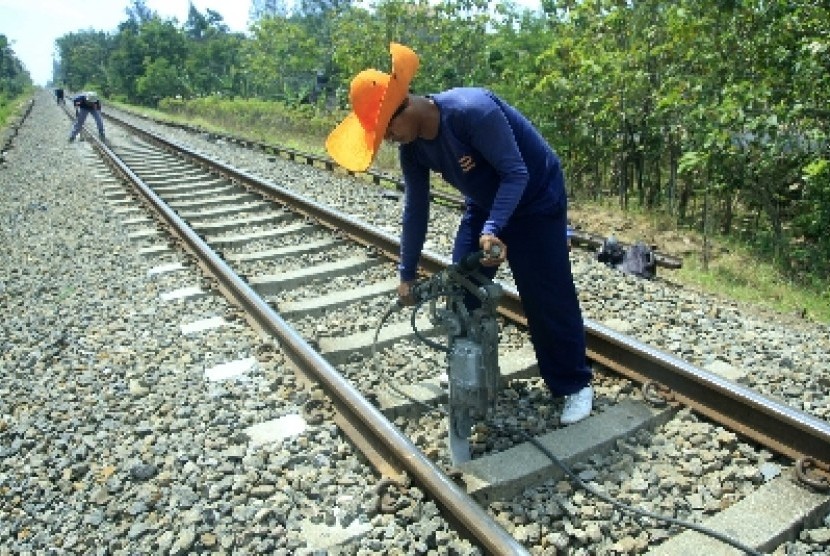  Seorang pekerja tengah melakukan perawatan rel kereta api. 