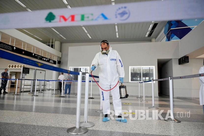  Seorang pekerja yang mengenakan pakaian pelindung semprotan desinfektan sebagai tindakan pencegahan terhadap penyebaran Covid-19 Coronavirus di bandara internasional Rafic Hariri di Beirut, Lebanon (ilustrasi) 