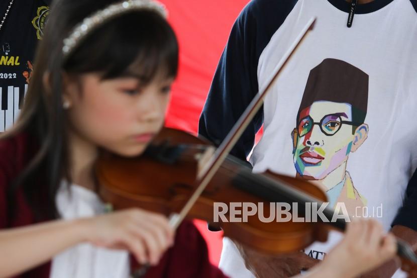 Seorang pelajar memainkan biola saat berziarah di makam WR Soepratman (ilustrasi). Pemerintah menegaskan penggunaan lagu Indonesia tidak dikenakan royalti.