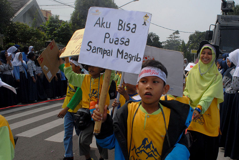 Seorang pelajar Sekolah Alam Indonesia membawa poster bertuliskan ''Aku Bisa Puasa Sampai Magrib'' saat mengikuti Pawai Tarhib Ramadan di Sukabumi, Jawa Barat, Rabu (24/5). 