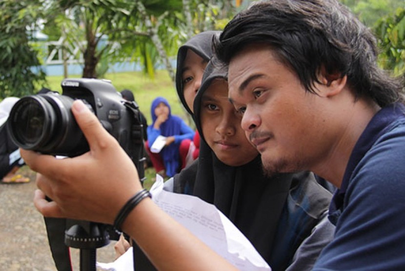 Seorang pelajar serius menyaksikan penggunaan kamera untuk pembuatan film