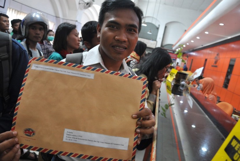 Seorang pelamar calon pegawai negeri sipil (CPNS) memperlihatkan berkas pendaftaran lamarannya untuk dikirim di Kantor Pos Besar Medan, Sumatera Utara, Senin (15/10). 