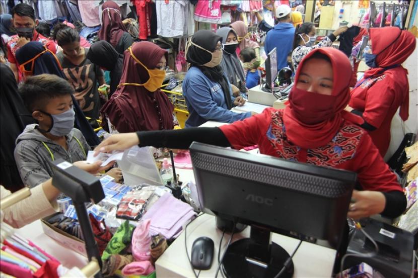 Seorang pelanggan bertransaksi di satu toko pakaian di Pasar Bogor, menjelang hari raya Idulfitri yang dibayangi pandemi virus korona (Covid-19) pada 19 Mei 2020 di Bogor, Jawa Barat.