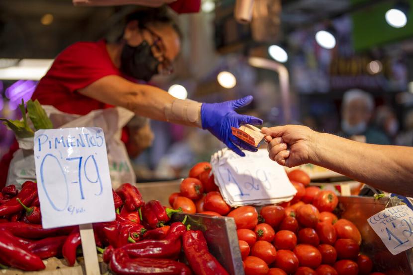 Seorang pelanggan membayar sayuran di pasar Maravillas di Madrid, Spanyol. Tingkat inflasi Spanyol naik 9,3 dalam 12 bulan hingga September. Data Institut Statistik Nasional menunjukkan pada Kamis, penurunan inflasi lebih dari 1 poin persentase, berkat penurunan harga transportasi umum dan penurunan harga listrik.