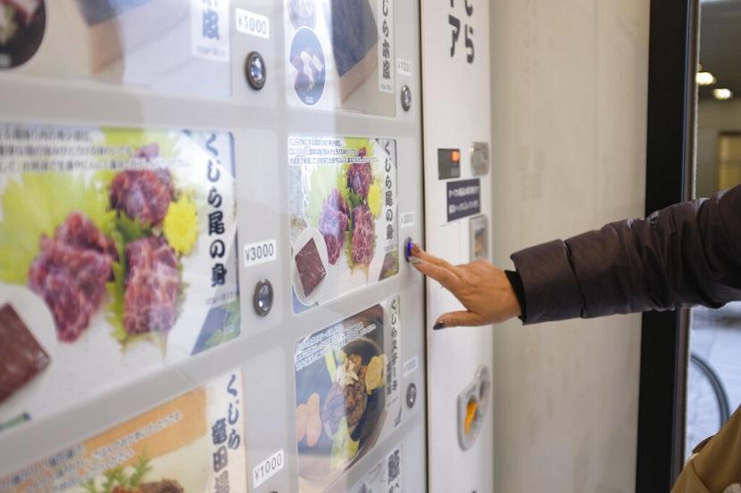 Seorang pelanggan membeli daging paus dari mesin penjual otomatis di Kyodo Senpaku, Kamis, 26 Januari 2023, di Yokohama, Jepang.