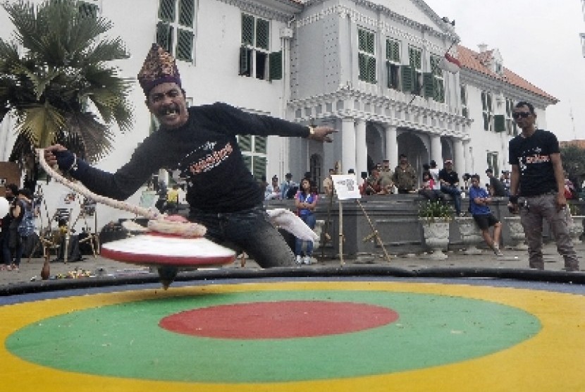 Seorang pemain gasing yang tergabung dalam Komunitas Gasing Indonesia menunjukkan permainannya di Kawasan Kota Tua, Jakarta.