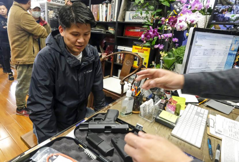 Seorang pembeli mengambil senjatanya di sebuah toko senjata di Arcadia, California, pada 15 Maret 2020. Produksi senjata di Amerika Serikat (AS) naik hampir tiga kali lipat sejak tahun 2000.