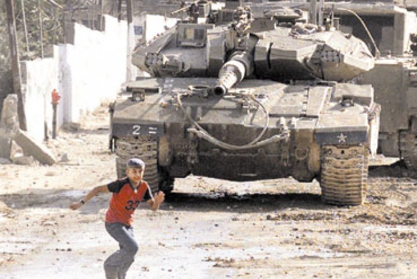 Seorang pemuda Palestina lari setelah dibidik tank Israel.