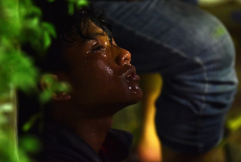 Seorang pendemo bersandar di pohon usai terkena tembakan gas air mata saat bentrok polisi dan massa di jalan MH Thamrin, Jakarta, Kamis (23/5/2019) dini hari. 