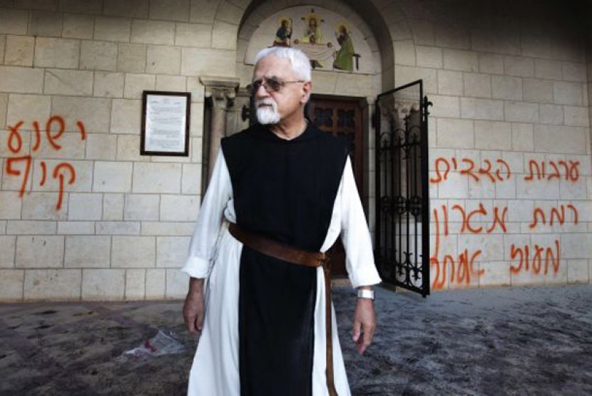 Seorang pendeta berdiri di depan tembok Gereja di Latrun, Lembah Ayalon, Yerussalaem. Gereja ini baru saja menjadi korban serangan ekstrimis pemukim Israel, 4 September 2012.