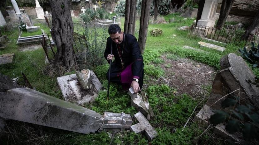 Seorang pendeta mendatangi tempat lokasi perusakan makam di pemakaman Protestan di Gunung Zion, Yerusalem. Batu nisan dan salib dirusak pemukim Yahudi. Palestina Kecam Perusakan Makam Kristen oleh Pemukim Yahudi di Yerusalem